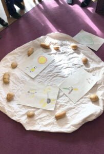 Potatoes lying in a circle on blanket illustrate the potato cycle with its different stages